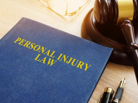 Personal injury law on a desk and gavel.